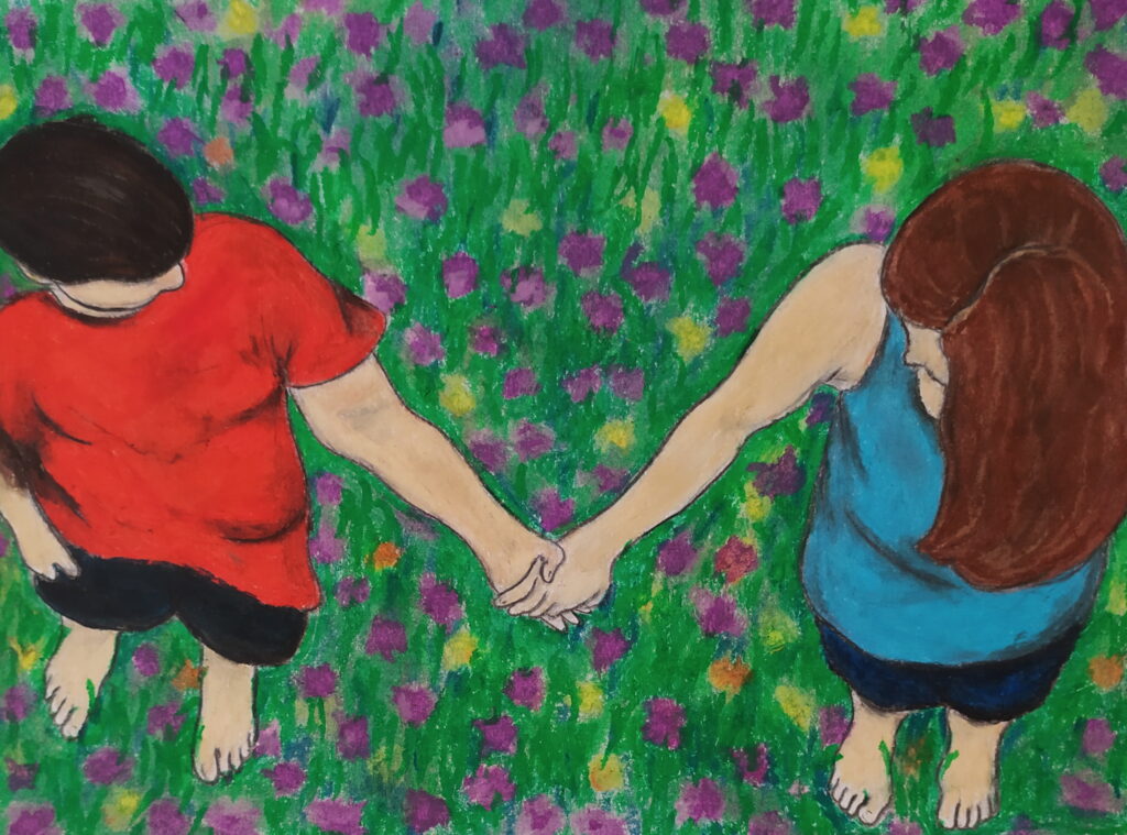 A birds eye view of two people standing in a field of yellow and purple flowers. The two people are holding hands and looking at each other.