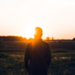 Person standing and looking into a sunset