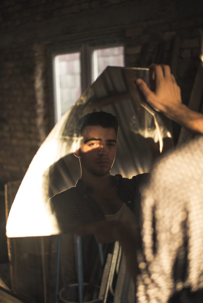 Image of a man looking into a broken mirror